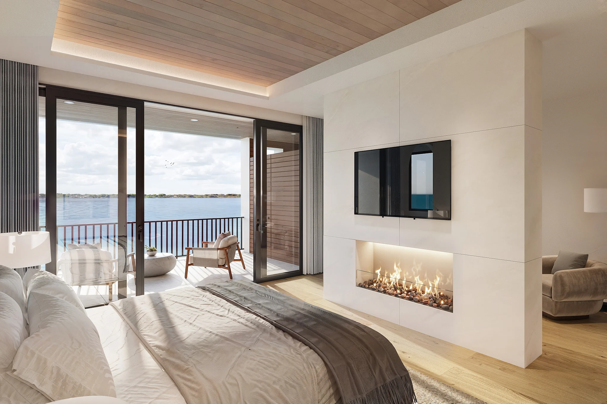 Modern bedroom in Lake Norman townhomes with a fireplace, TV, and a balcony offering a serene lake view.