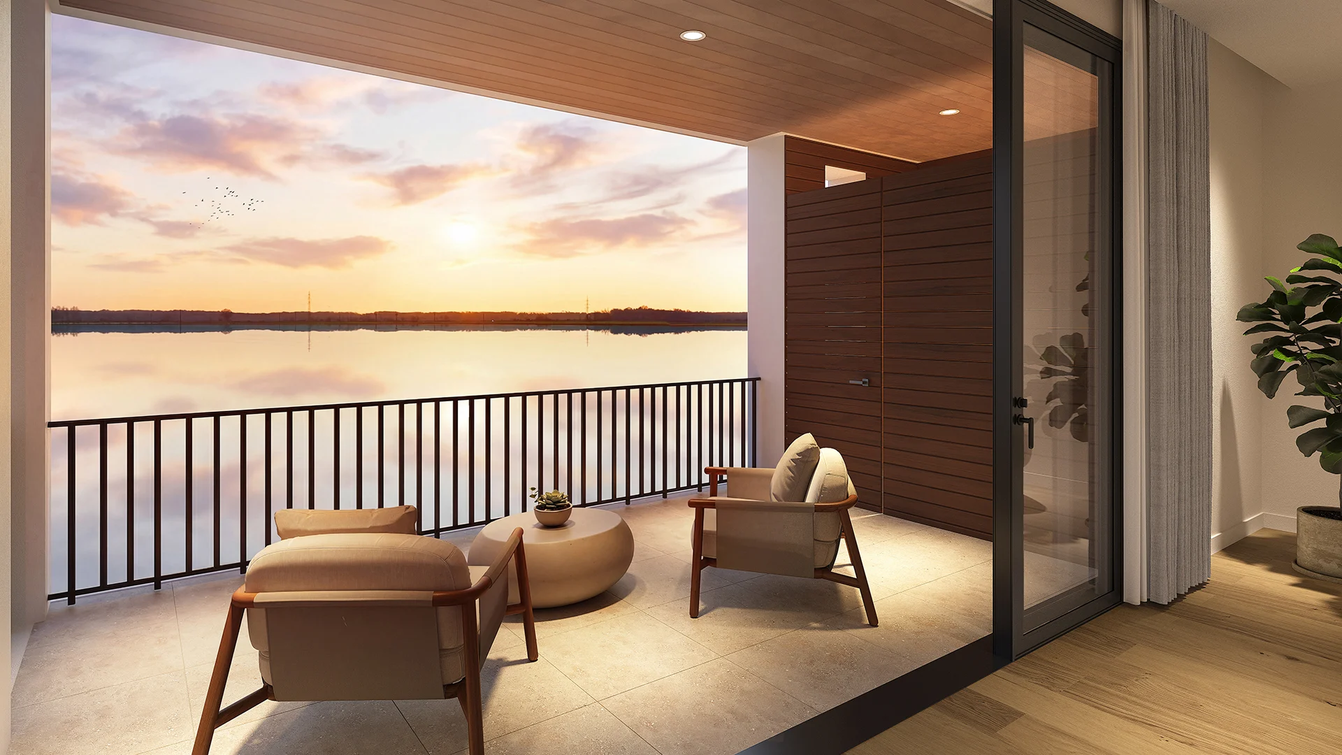 Balcony sunset view over Lake Norman from townhomes, with cozy chairs and a small table, offering a serene atmosphere.